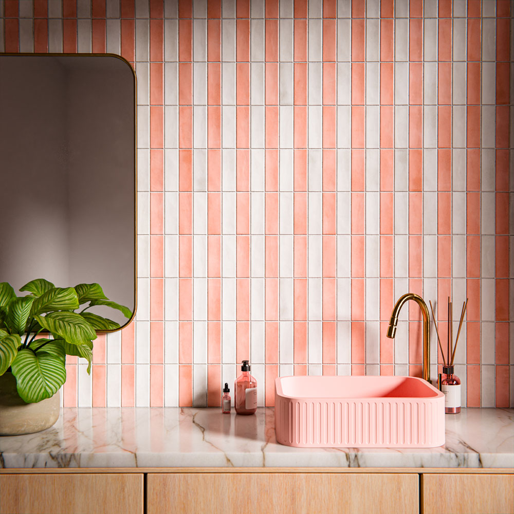 Waschtischbereich im Badezimmer mit Benomar Ziegelfliesen im marokkanischen Stil in Rosé- und Elfenbeintönen, vertikal verlegt, kombiniert mit rosafarbenem Waschbecken, Messingarmatur, Marmoroberfläche und Pflanzen.