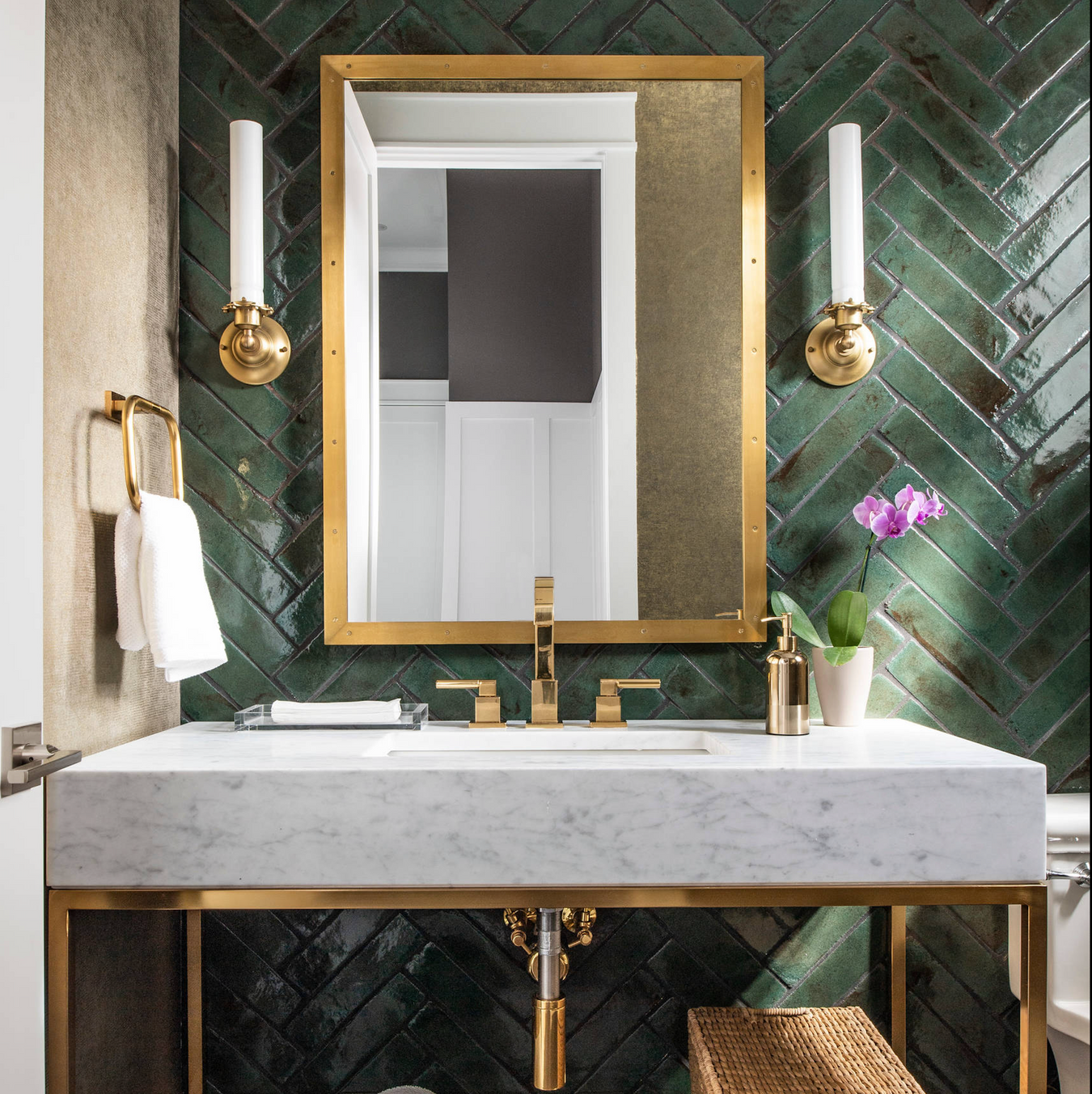 Kücheninterieur mit glänzenden Elazar Ziegelfliesen in gemischten Blau- und Weißtönen, vertikal in einer Nische als Statement verlegt, kombiniert mit marineblauen Schränken, Messingakzenten und einer Marmoroberfläche in einem klassisch-modernen Ambiente.