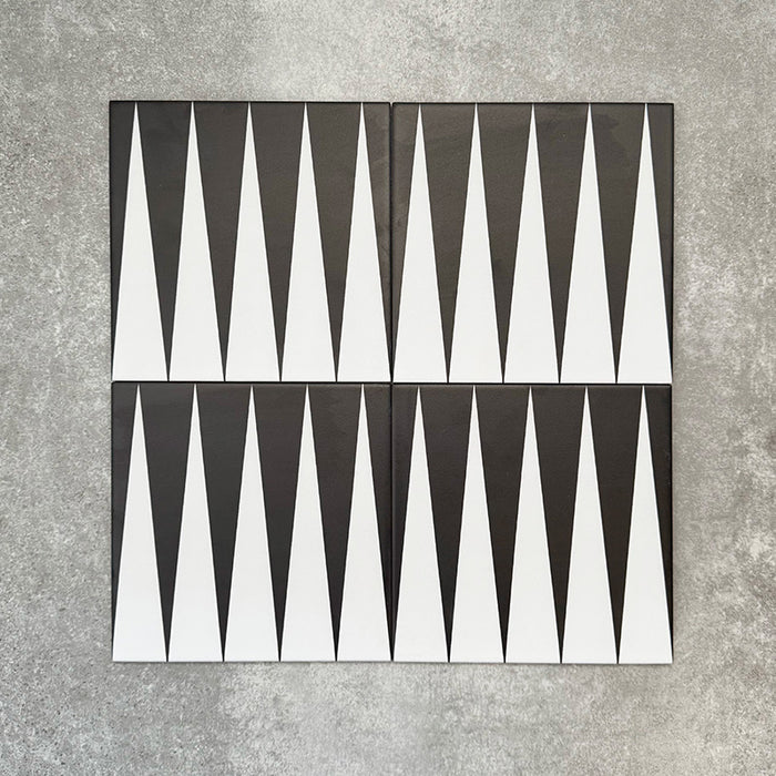 Schwarz-weiße Bodenfliese im Format 20x20 cm mit ausdrucksstarkem, geometrischem Muster im Backgammon-Stil. Markante Dreiecksformen treffen auf einen strukturierten grauen Hintergrund und schaffen eine klare, grafische Wirkung.