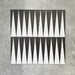 Schwarz-weiße Bodenfliese im Format 20x20 cm mit ausdrucksstarkem, geometrischem Muster im Backgammon-Stil. Markante Dreiecksformen treffen auf einen strukturierten grauen Hintergrund und schaffen eine klare, grafische Wirkung.