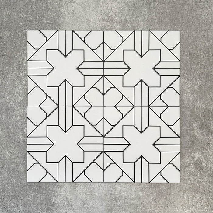 Vier Almeira Palast Feinsteinzeugfliesen im marokkanischen Stil für Wand und Boden, gemeinsam präsentiert mit einem feinen geometrischen Linienmuster in Schwarz auf weißem Grund, Format 20 × 20 cm.