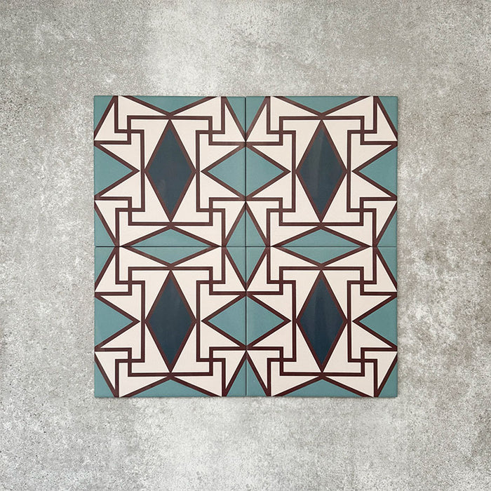 Abstrakter Iris Musterfliese im Format 20 × 20 cm, in einem wiederholten Raster verlegt, um das detailreiche geometrische Design zu zeigen. Sanfte Petrol- und Cremetöne stehen im Kontrast zu tiefblauen Rautenmotiven und feinen roten Details und ergeben ein ausdrucksstarkes, dekoratives Muster – ideal für Akzentwände, Bodenflächen oder ausdrucksstarke Küchenrückwände.