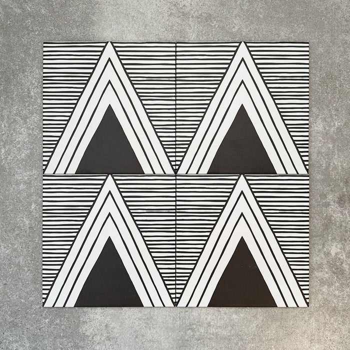 Vier Almeira Giza Feinsteinzeugfliesen im marokkanischen Stil für Wand und Boden, gemeinsam präsentiert in einem markanten geometrischen Dreiecksmuster in Schwarz und Weiß, Format 20 × 20 cm.