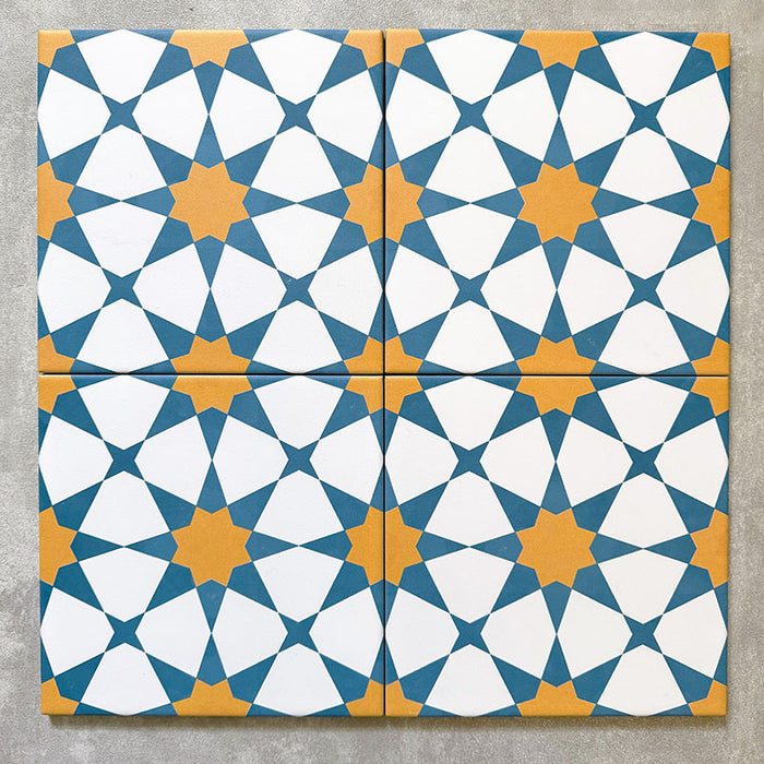 Agadir Blau & Gelb Fliesen im marokkanischen Stil im Format 20 × 20 cm aus Feinsteinzeug, als Vierer-Anordnung dargestellt, um das sich wiederholende geometrische Sternmuster in Blau, Weiß und warmem Gelb auf neutralem Hintergrund zu präsentieren.