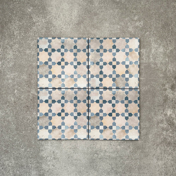 Vier Berber Mequinez Blau Feinsteinzeugfliesen im marokkanischen Stil im Format 15 × 15 cm, gemeinsam angeordnet, um das sanfte geometrische Muster in Blau und Creme auf neutralem Hintergrund hervorzuheben.