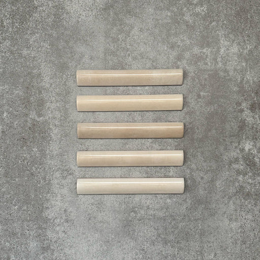 Zellige Beige Bullnose-Keramikfliesen im marokkanischen Stil in warmem Beigeton, sauber als Flatlay arrangiert.