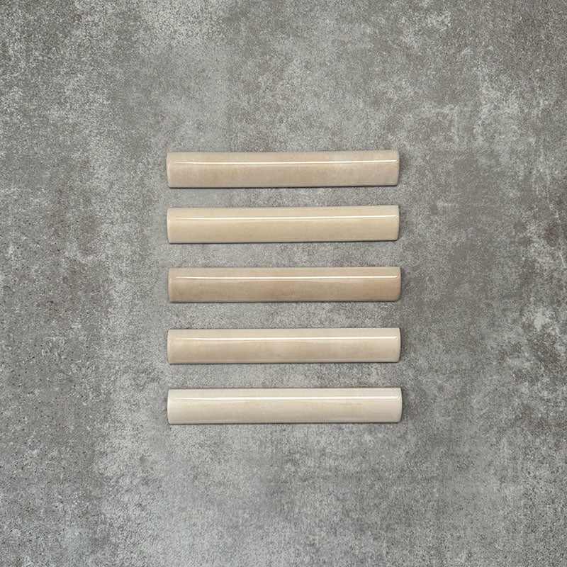 Zellige Beige Bullnose-Keramikfliesen im marokkanischen Stil in warmem Beigeton, sauber als Flatlay arrangiert.