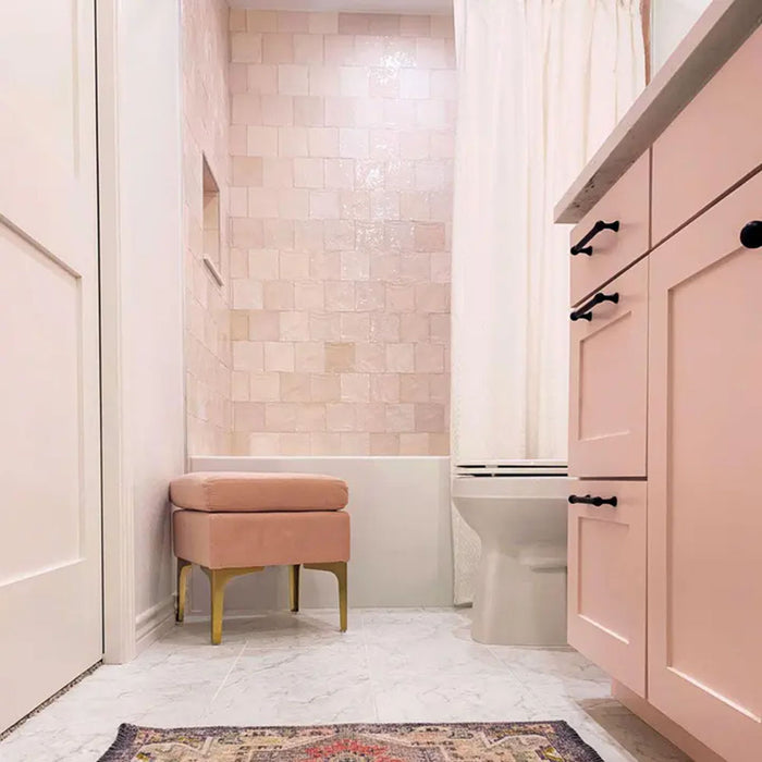 Badezimmer mit Zellige Rosa Nebel Quadrat Keramik-Wandfliesen im marokkanischen Stil im Format 13,2 × 13,2 cm, in einem gleichmäßigen Raster rund um den Badebereich verlegt. Kombiniert mit rosafarbenen Schrankfronten, weißen Armaturen und dezenten Metallakzenten entsteht ein ruhiger, eleganter Look mit Zellige-Effekt.