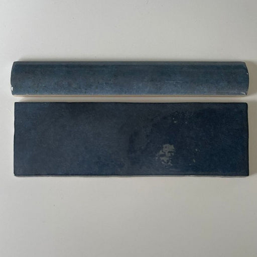 Zellige Königliches Blau Bordürenfliese, oberhalb einer passenden Ziegelfliese dargestellt. Die tief königsblaue, glänzende Glasur mit natürlicher Farbvariation sorgt für einen glatten, hochwertigen Abschluss bei Wandgestaltungen im marokkanischen Stil.