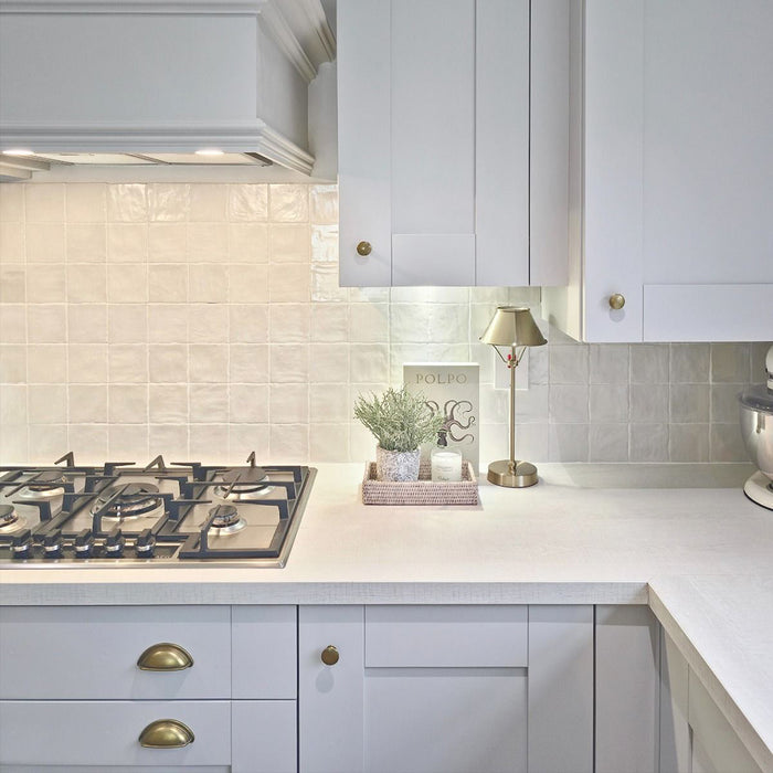 Küchenrückwand mit Zellige Auster Quadrat Fliesen im marokkanischen Stil im Format 10 × 10 cm, mit sanft glänzender Oberfläche, im klaren Raster verlegt, um einen hellen, strukturierten Hintergrund mit feiner handwerklicher Variation zu schaffen.