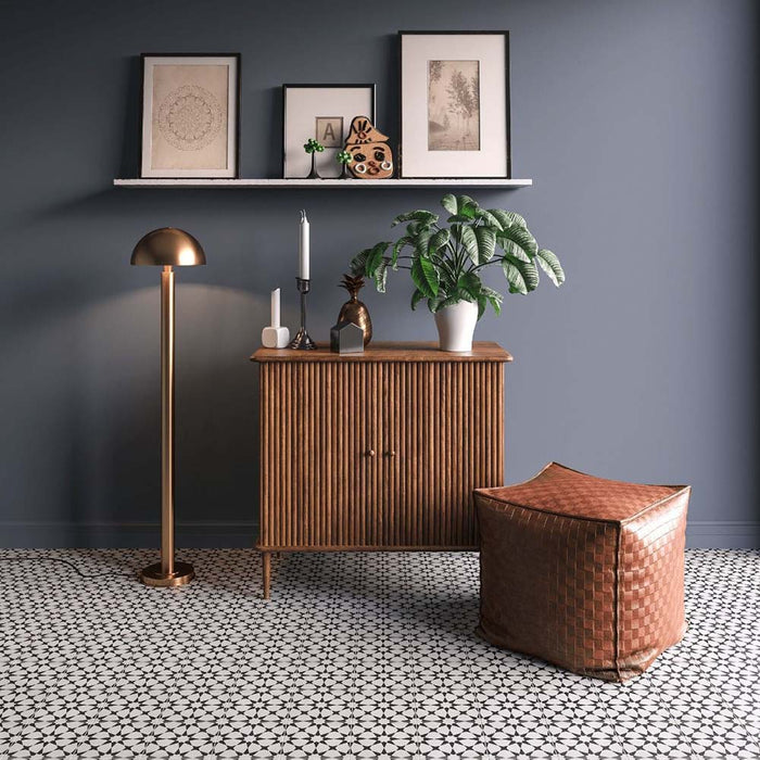 Wohnzimmer mit Agadir MINI Schwarz & Weiß Fliesen im marokkanischen Stil im Format 15 × 15 cm, verlegt als ausdrucksstarker Bodenbelag. Kombiniert mit Holzmöbeln im Mid-Century-Stil, Messingleuchten, gerahmten Kunstwerken und sanft grauen Wänden für ein stilvolles Gesamtbild.