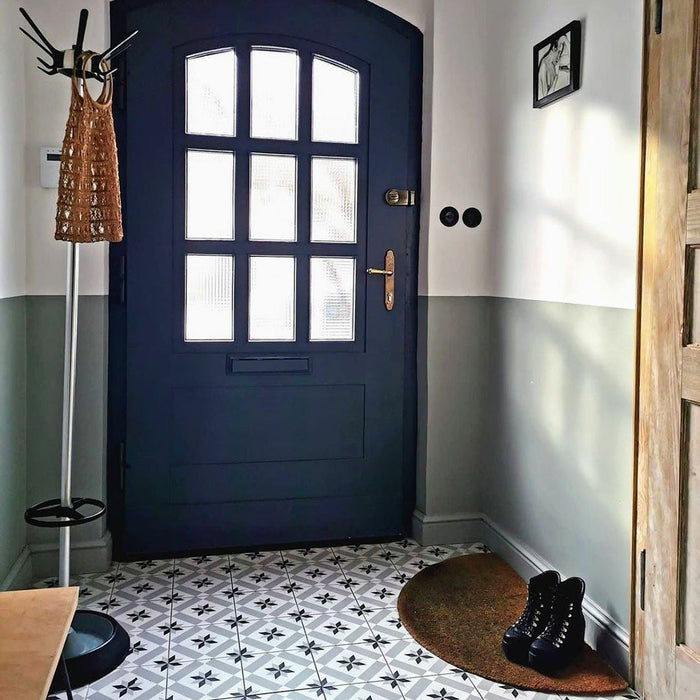 Eingangsflur mit Canterbury Stern Bodenfliesen im viktorianischen Stil im Format 20 × 20 cm, die einen klassischen schwarz-grau-weißen Musterboden bilden. Kombiniert mit marineblauer Haustür, gestrichenen Wänden und schlichten, rustikalen Accessoires.