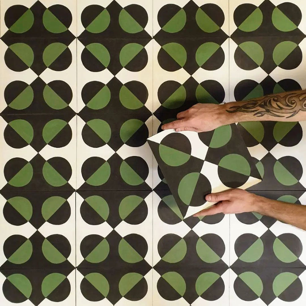 Abstrakter Illusion Verde Noir Musterfliese im Format 20 × 20 cm, in einem wiederholten Raster verlegt, um das markante Design mit optischer Illusion hervorzuheben. Tiefschwarze und sattgrüne, geschwungene Formen erzeugen ein ausdrucksstarkes, kontrastreiches geometrisches Muster, gezeigt während der Verlegung, um zu veranschaulichen, wie sich das Design über Bodenflächen oder Akzentwände hinweg ausrichtet und wiederholt.