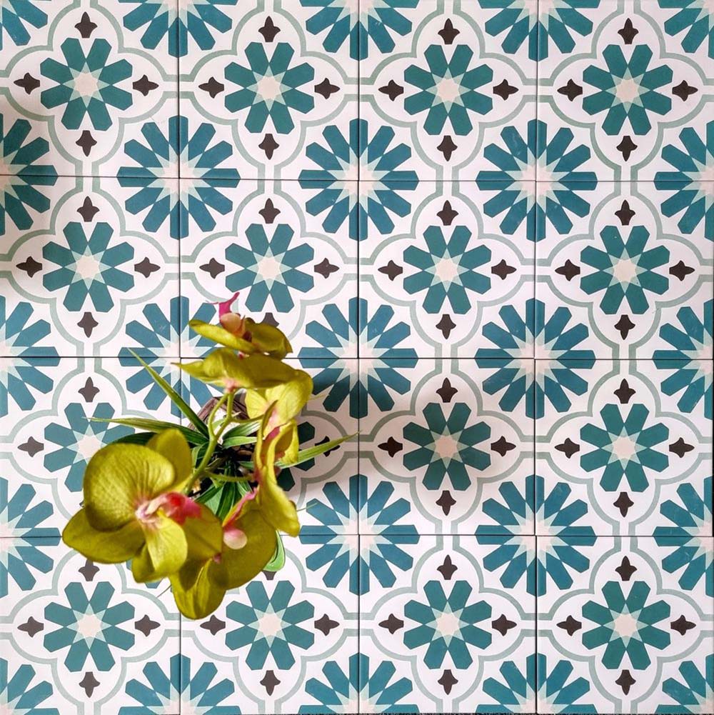 Clara Petrol Feinsteinzeugfliesen im viktorianisch-marokkanischen Stil im Format 20 × 20 cm, verlegt in einem sich wiederholenden Muster, das das blaugrüne geometrische Design in Petrol- und Grüntönen über die gesamte Fläche hinweg zur Geltung bringt.