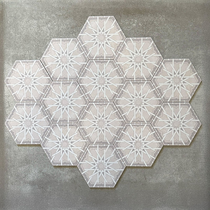 Gruppierte Anordnung von Medina Hormuz Schneeweiß Feinsteinzeug-Hexagonfliesen im marokkanischen Stil im Format 18,7 × 21,6 cm, die das vollständig wiederholte, sterninspirierte geometrische Muster in Weiß- und sanften Grautönen auf neutralem Hintergrund zeigt.