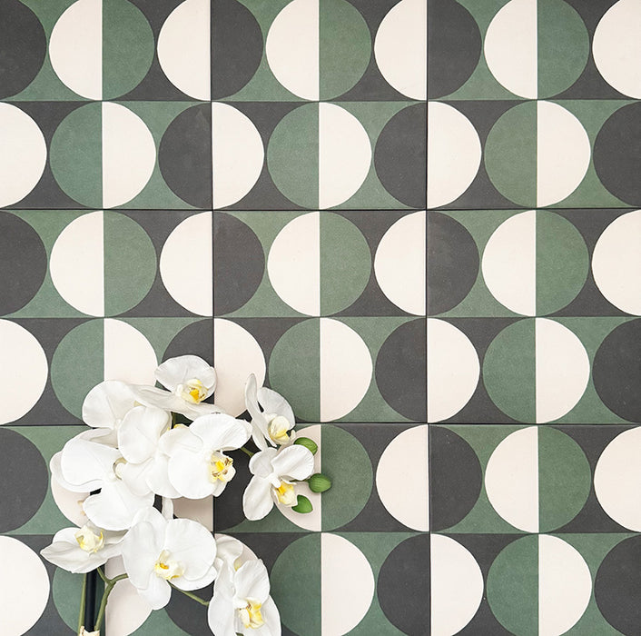 Abstrakte Kreise Musterfliese im Format 20 × 20 cm, in einem wiederholten Raster dargestellt, um das markante kreisförmige Design hervorzuheben. Tiefe Grüntöne, Anthrazit und sanfte Cremenuancen bilden ein ausdrucksstarkes und zugleich ausgewogenes Muster, in Szene gesetzt mit floralen Akzenten, um die Fliesen als dekoratives Element für Boden-, Wand- oder Spritzschutzflächen zu präsentieren.