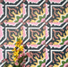 Dekoratives Interior mit Kuba Havana Feinsteinzeugfliesen im marokkanischen Stil im Format 20 × 20 cm, mit kräftigem geometrischem Muster in Navy-, Rosa-, Grün- und Senftönen, stilvoll ergänzt durch florale Akzente zur Betonung des farbenfrohen, dekorativen Designs.