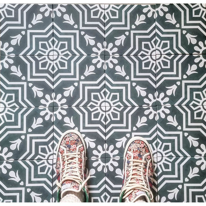 Innenraumszene mit Berlin Grün Fliesen im Format 20 × 20 cm im viktorianisch inspirierten Stil in Grün und Weiß. Auffällige geometrische und florale Motive kombiniert mit gemusterten Sneakern für eine moderne, lifestyle-orientierte Darstellung.
