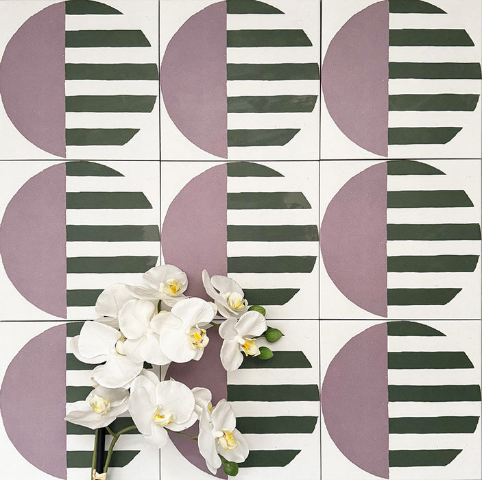 Abstrakter Serit Musterfliese im Format 20 × 20 cm, in einem wiederholten Raster verlegt, um das ausdrucksstarke geometrische Design zu zeigen. Sanft rosafarbene Halbkreise werden mit tiefgrünen horizontalen Streifen auf klarem weißem Hintergrund kombiniert und ergeben ein verspieltes, zugleich zeitgemäßes Muster – ideal für Akzentwände, Bodenflächen oder ausdrucksstarke Küchenrückwände.