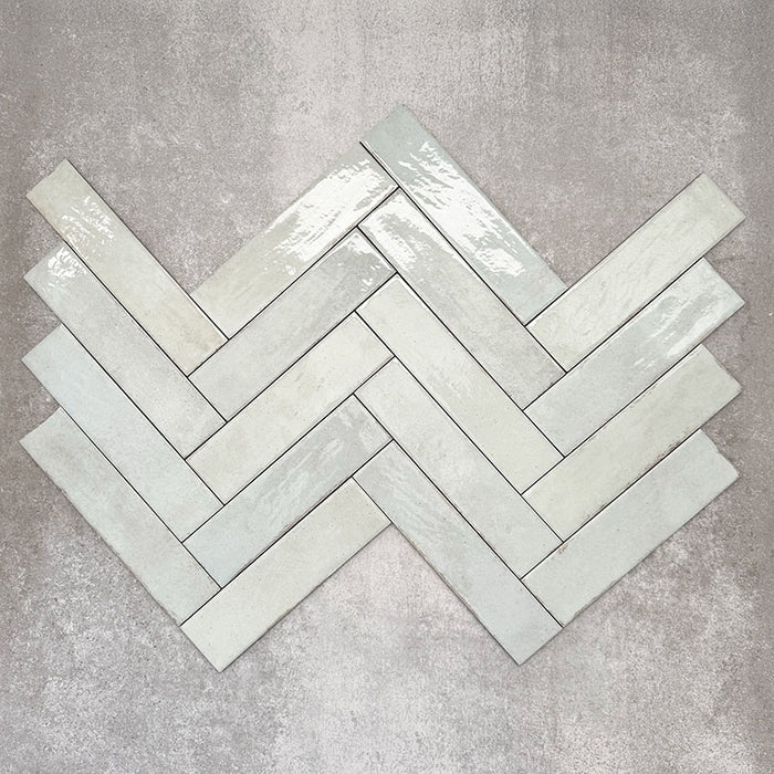 Nomadin Brick Mintgrün Wandfliesen im Format 6 × 24,6 cm, im Fischgrätmuster verlegt, um den sanften Grünton, die glänzende Oberfläche und die feine Oberflächenvariation hervorzuheben.