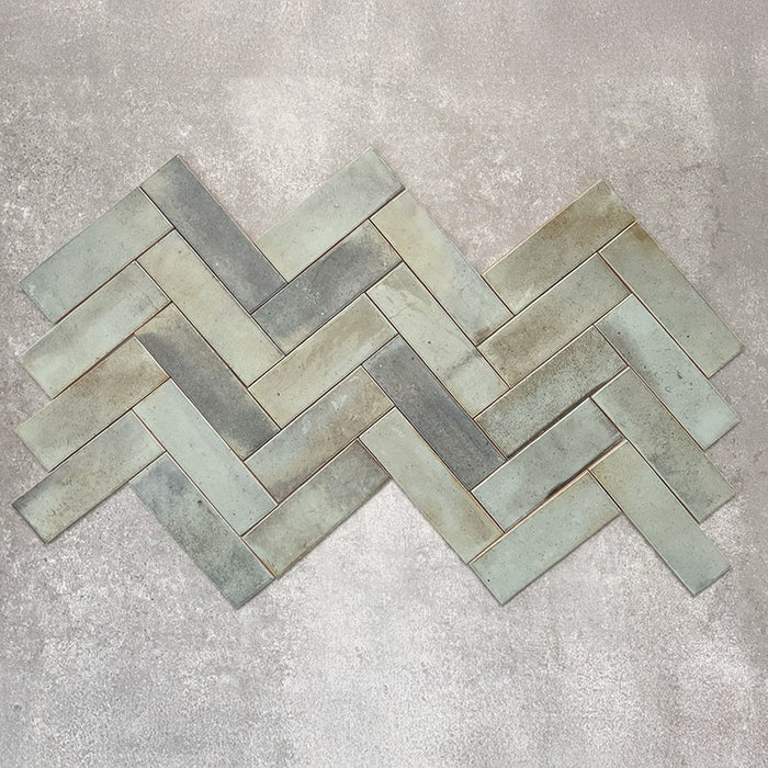 Saigon Seladongrün Brick Wandfliesen im Fischgrätmuster verlegt. Marokkanisch inspirierte Keramikfliesen im Format 5,1 × 16,1 cm mit sanfter Grün- und Blau-Grau-Tonvariation.