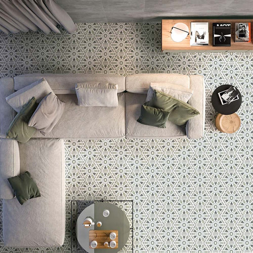 Wohnbereich mit Medina Hormuz Salbeigrün / Grau Porzellanfliesen im marokkanischen Stil im Hexagonformat (18,7 × 21,6 cm), verlegt in einem markanten geometrischen Muster und kombiniert mit modernen Sitzmöbeln sowie weichen, neutralen Textilien.