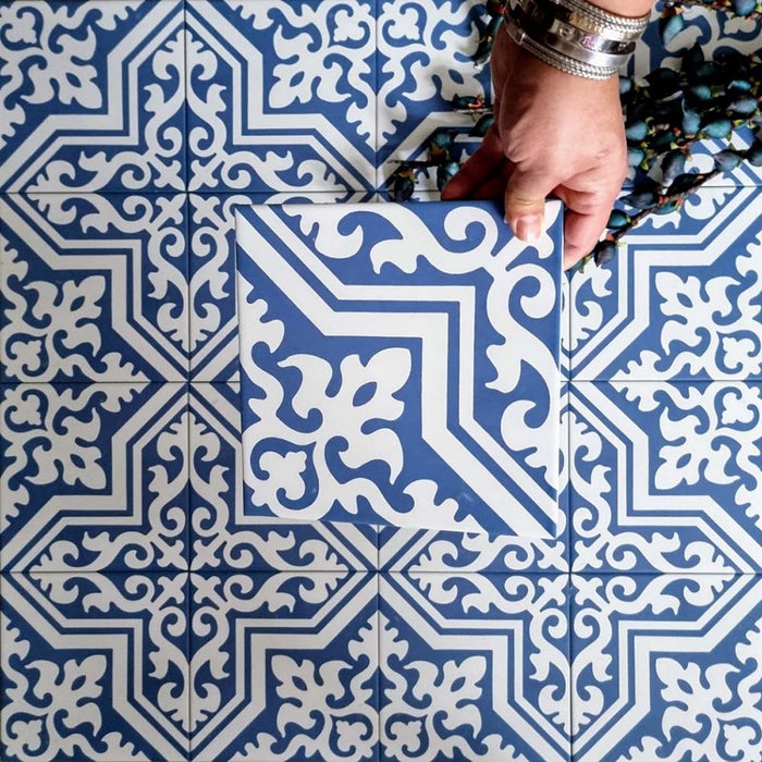 Draufsicht auf Berlin Trondite Feinsteinzeugfliesen im Format 20 × 20 cm im viktorianisch-marokkanisch inspirierten Stil, verlegt in einem sich wiederholenden Muster in Blau und Weiß.