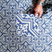 Draufsicht auf Berlin Trondite Feinsteinzeugfliesen im Format 20 × 20 cm im viktorianisch-marokkanisch inspirierten Stil, verlegt in einem sich wiederholenden Muster in Blau und Weiß.
