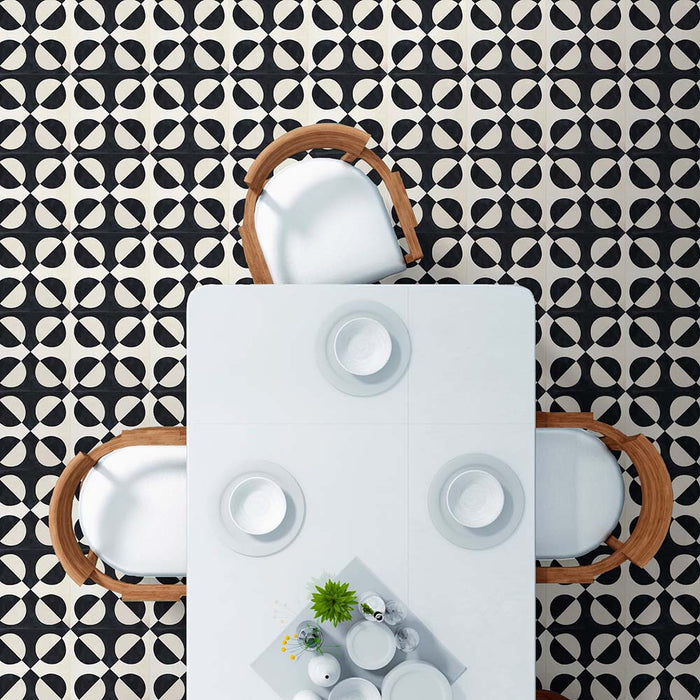 Essbereich, gestaltet mit  Abstrakte Schwarze Illusion Musterfliese im Format 20 × 20 cm, verlegt als markantes geometrisches Bodendesign. Das kontrastreiche Kreis­muster in Schwarz und sanftem Creme erzeugt einen eindrucksvollen Effekt optischer Illusion und wird mit einem weißen Esstisch und Holzstühlen kombiniert – für ein klares, modernes Interieur.