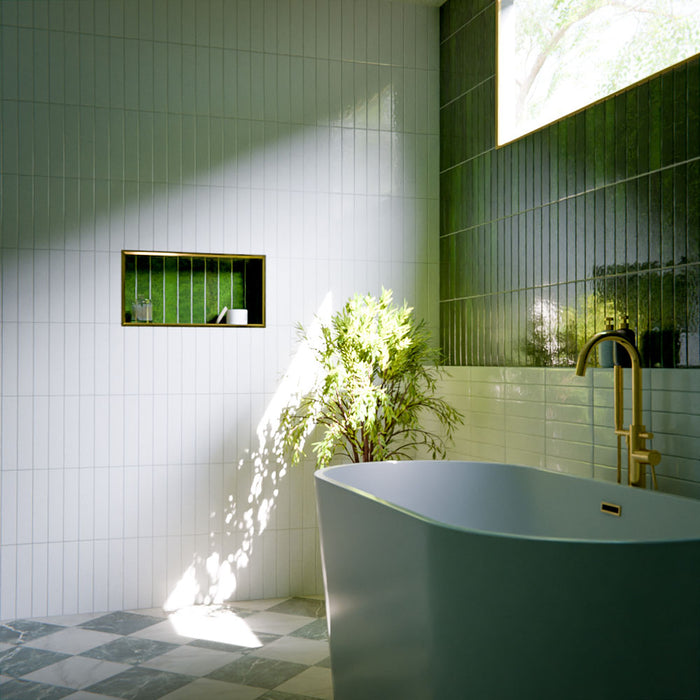Modernes Badezimmer mit Bora Bora Ziegel Weißer Sand Keramik-Wandfliesen im schlanken Riemchenformat 6,5 × 32,8 cm mit Fluxglasur, vertikal und horizontal verlegt, um eine weich strukturierte Akzentwand zu schaffen. In Kombination mit freistehender Badewanne, Messingarmaturen, natürlichem Licht und Pflanzen entsteht eine ruhige, spaähnliche Atmosphäre.