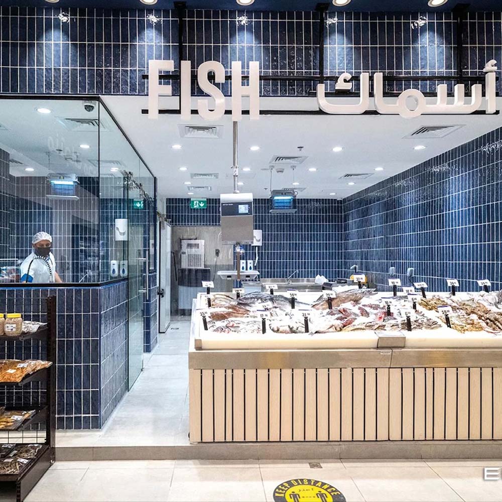 Innenraum einer Fischtheke mit Zellige Königliches Blau Ziegel Fliesen im marokkanischen Stil im Format 6,5 × 20 cm. Die glänzende königsblaue Oberfläche ist vertikal an den Wänden verlegt und schafft ein markantes, sauberes und zeitgemäßes Ambiente im Einzelhandel.