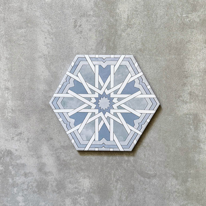 Einzelne sechseckige Porzellanfliese Medina Hormuz Azurblau im marokkanischen Stil (18,7 × 21,6 cm) mit einem ausdrucksstarken, sterninspirierten geometrischen Muster in sanften Blau- und Weißtönen, gezeigt vor neutralem Hintergrund.