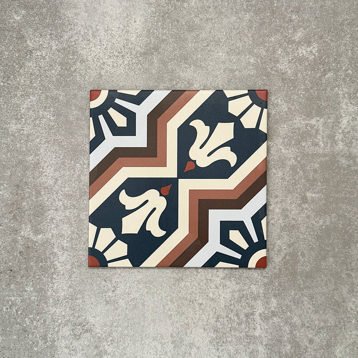 Einzelne Berlin Großartig Feinsteinzeugfliese im Format 20 × 20 cm im marokkanisch inspirierten Stil vor einem neutralen Hintergrund in Steinoptik. Gezeigt wird ein detailreiches geometrisches Muster in tiefem Blau, warmem Braun und sanften Cremetönen mit traditionell inspiriertem Design und klarer matter Oberfläche.