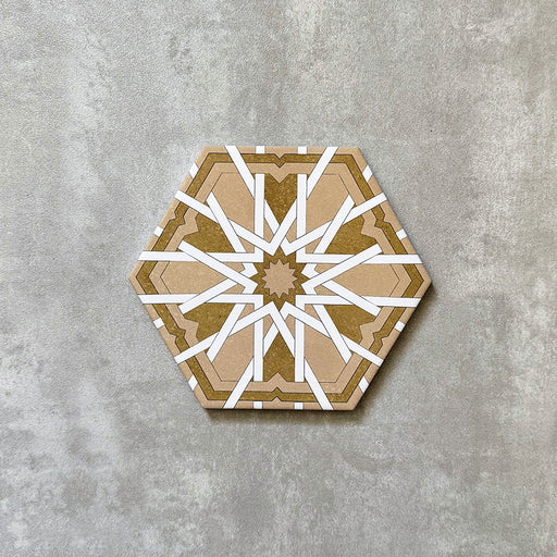 Einzelne Medina Hormuz Vintage Gold Hexagon-Porzellanfliese im marokkanischen Stil, 18,7 × 21,6 cm, mit einem ausdrucksstarken, sterninspirierten geometrischen Muster in warmen Gold- und Weißtönen, auf neutralem Hintergrund dargestellt.