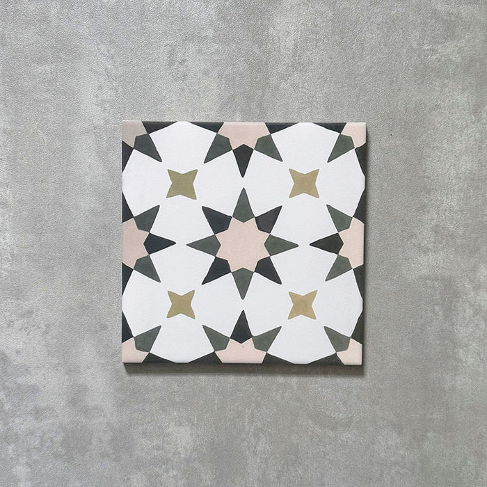 Einzelne Agadir Beige Fliese im marokkanischen Stil im Format 20 × 20 cm aus Feinsteinzeug mit einem zurückhaltenden geometrischen Sternmuster in Weiß, ergänzt durch gedeckte Beige-, Oliv- und Anthrazitakzente auf einer leicht strukturierten Oberfläche.
