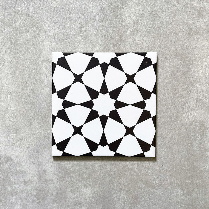 Einzelne Agadir Schwarz & Weiß Fliese im marokkanischen Stil im Format 20 × 20 cm aus Feinsteinzeug mit einem markanten geometrischen Sternmuster in Schwarz und Weiß, dargestellt auf neutralem Hintergrund.