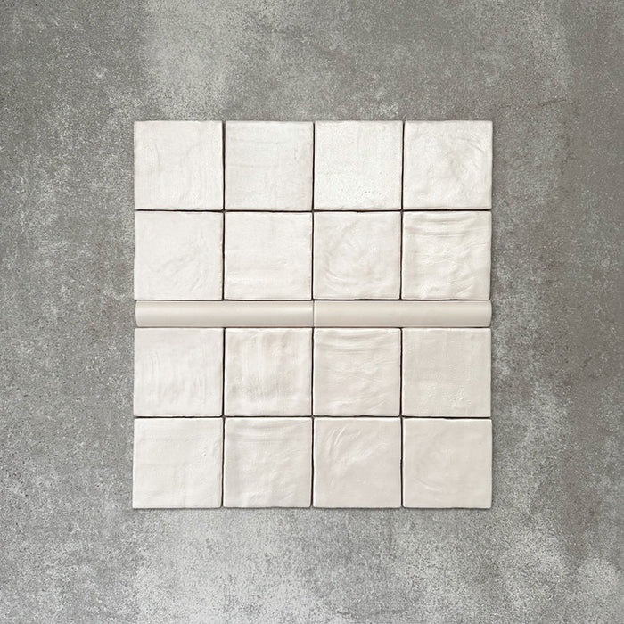 Zellige Auster Quadratfliesen mit passender Bullnose-Abschlussfliese in Auster-Weiß, flach ausgelegt, um Textur und Form hervorzuheben.